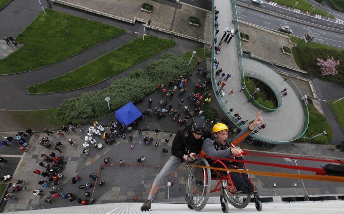 Альпинисты помогают Якубу Коуцки (справа), выпускнику университета для инвалидов «Jedlickuv Institute» подняться в инвалидном кресле на крышу пражского Конгресс-центра, 4 мая 2013 года. Фото: REUTERS/Petr Josek 